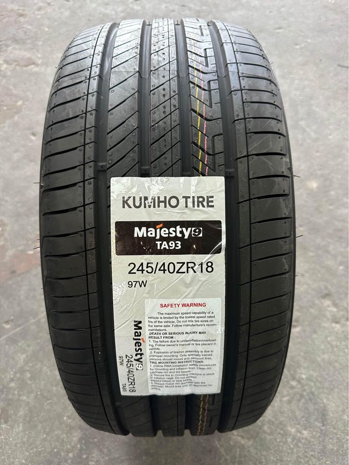 A new KUMHO TA93 MAJESTY9 tyre with the label visible, showing tread pattern and branding.